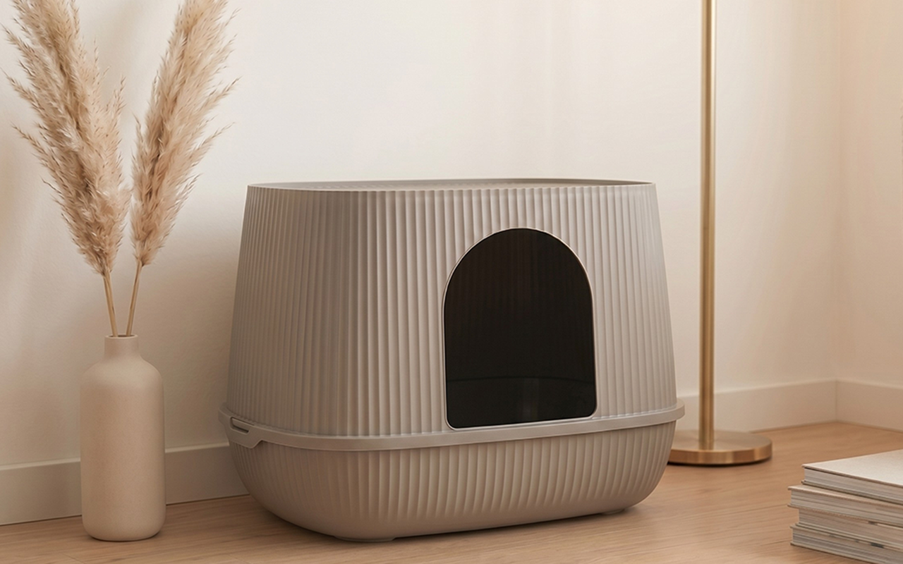Savic Moona covered cat litter box in warm grey with ribbed structure, in a light living room.